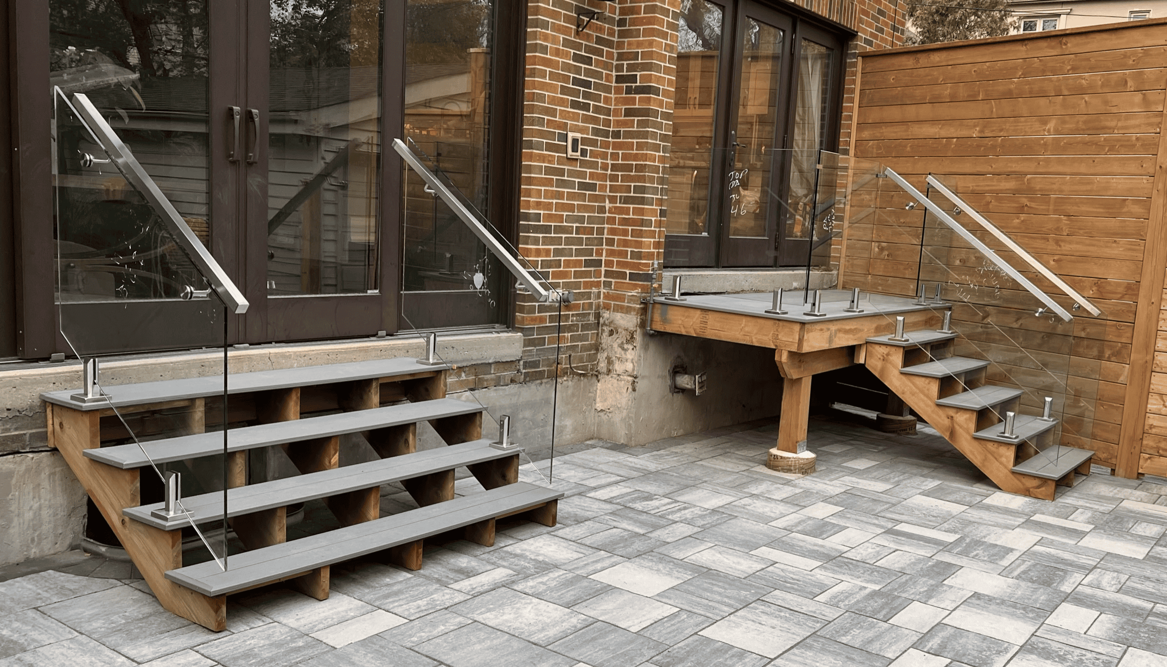 Glass and stainless steel railing on a custom wood deck in Toronto — modern design and structural durability by Zelux Railings, serving homes across the GTA.